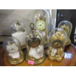 A mixed lot of clocks in individual glass domes, including Kein and Koma