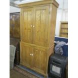 A large Victorian pine cabinet having four cupboard doors revealing fitted compartments and shelves,