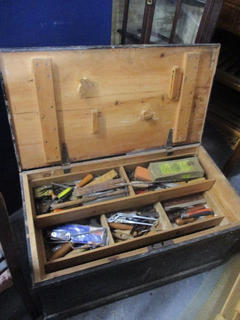 A pine tool chest containing a large selection of tools to include wood working planes, drill