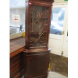 A late 20th century reproduction mahogany corner cabinet with glazed astragal door, above single