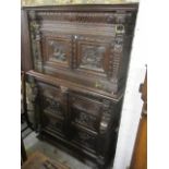 A mid 19th century continental oak press having four carved, panelled doors of figures, lion mask