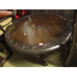 An oak circular topped coffee table having a carved border and standing on block feet, 18"h x 40"dia
