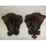 A pair of late 19th century German Black Forest wall brackets, each with a serpentine shelf over a