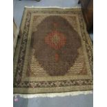 A 20th century hand woven Persian design red and brown ground woollen rug with multi guard borders