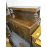 A 1930s oak sideboard having a raised back, bulbous supports, two drawers and two cupboards, 50"h