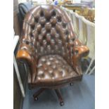 A reproduction brown leather, button upholstered swivel chair