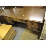 A reproduction oak desk having a central drawer flanked by four smaller drawers, 30" h x 50"w