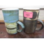 Two similar Troika mugs, one with a written mark