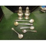 A pair of silver pepper pots and five silver condiment spoons