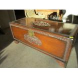 A mid 20th century camphor chest with carved oriental scenes to the lid and brass hardware