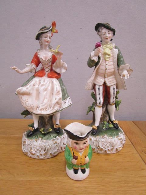 A pair of Kunst German porcelain early 20th century figurines A/F and a Devon pottery small Toby jug