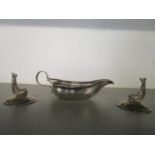 A pair of early 20th century menu holders in the form of dolphins, resting on conical bases and a