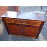 A Victorian and later mahogany side cabinet having three short drawers, twin cupboard doors and a