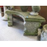 A weathered composition stone curved garden bench 40"w