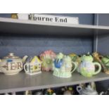 A collection of novelty teapots together with a Royal Stafford 2002 commemorative teapot