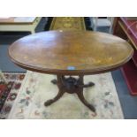 A Victorian walnut oval occasional table on turned columns, standing on splayed legs