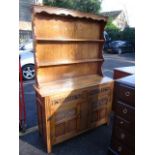 A reproduction oak display dresser having a plate rack above two drawers and two cupboards 76 1/4"