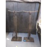 Two wrought metal fire iron sets on stands