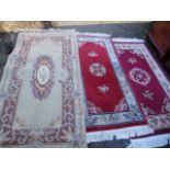 Three modern Chinese rugs to include two red ground rugs and one beige rug