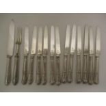 A set of twelve George III silver, shell pattern table knives by S P London 1816 and one blade by