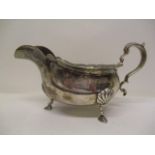 A silver sauce boat by Adie Brothers, Birmingham 1933, with a shaped lip and scrolled handle, on