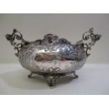 A late 19th century continental silver bowl stamped 935 with twin mask handles and embossed,