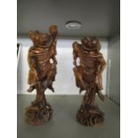 A pair of early 20th century Chinese carved wooden root carvings, each of a male figure with inset