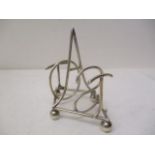 A Victorian silver toast rack by Hukin & Heath, London 1895, the divisions spelling TOAST, on a