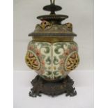 A Zsolnay Pecs pottery and brass oil lamp with pierced, domed ornament decorated in green, pink