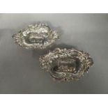 A matched pair of silver dishes with rococo scrolled leaf and pierced decoration, one hallmarked