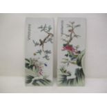 A pair of 20th century Chinese plaques, each decorated with birds on a branch, above rocks and