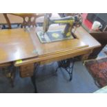 An early 20th century sewing machine table with inset Singer sewing machine