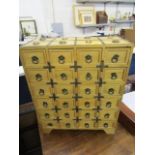 A 20th century Oriental soft wood table top cabinet with twenty-four drawers and ring handles