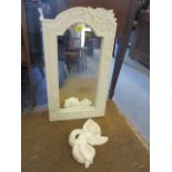 A modern white painted carved framed mirror and a white plaster cherub
