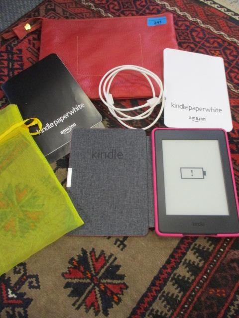 A Kindle Paperwhite in a pink case with a John Lewis red leather travelling bag, together with a