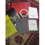 A Kindle Paperwhite in a pink case with a John Lewis red leather travelling bag, together with a