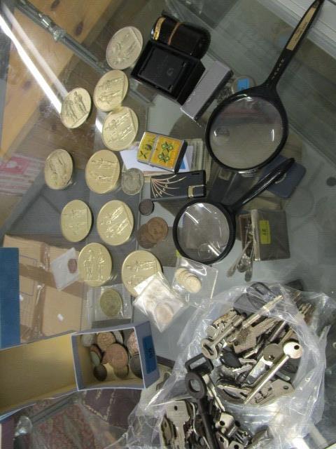 A mixed lot to include keys, two magnifying glasses, 1950s shooting medals, lighters, Zippo coins
