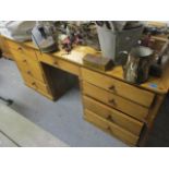 An Edwardian pine twin pedestal desk having one central drawer flanked by eight short drawers