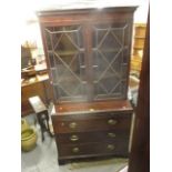 A George III and later mahogany and stained pine bookcase chest, with twin glazed doors, over a