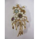 A 9ct gold brooch inset with seed pearls and semi precious stones