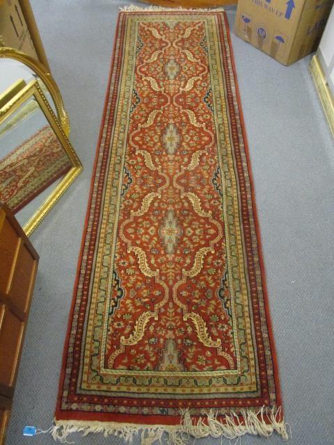 A Persian runner having a red ground, multiguard borders and tasselled ends, 102" x 29 1/2"