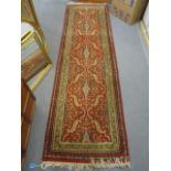 A Persian runner having a red ground, multiguard borders and tasselled ends, 102" x 29 1/2"