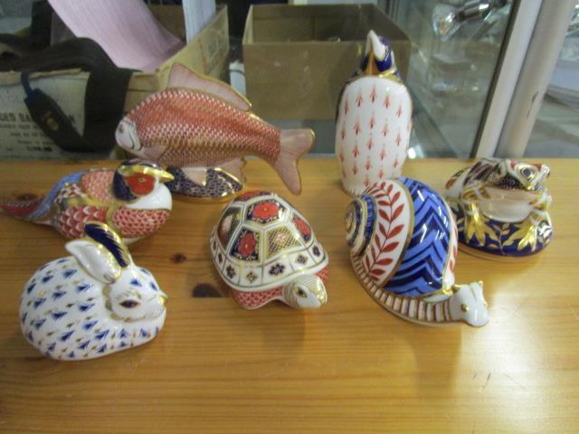 A collection of seven Royal Crown Derby animal paperweights, five with silver stoppers, to include a