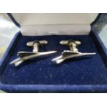 A pair of white metal cuff links in the form of Concorde