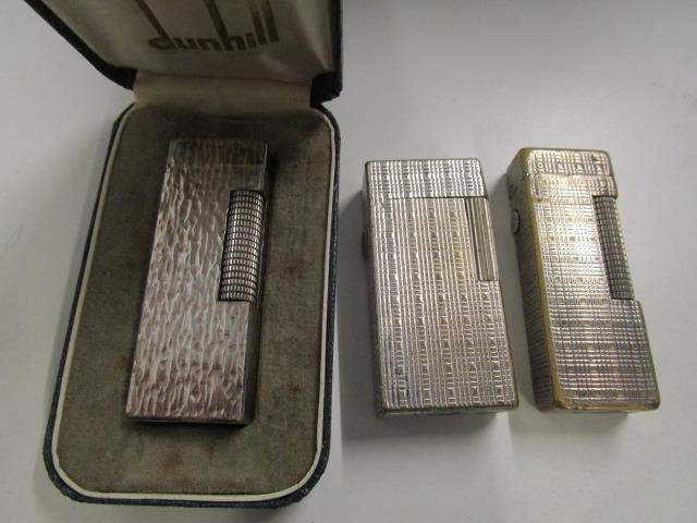 A 1970s Dunhill silver plated lighter with textured decoration, in box and two other Dunhill