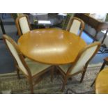 A mid 20th century teak circular extending table 28"h x 48"w and four chairs
