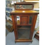 A Victorian walnut music cabinet with extended mirrored back supported on turned columns, above a