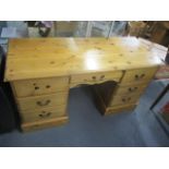 A modern pine kneehole desk having seven drawers with swan neck handles 30"h x 53 1/2"w