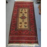 A Bokhara red ground rug decorated with birds, a central medallion and geometric designs, 62" x 31"