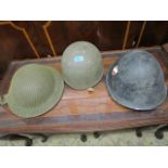 A group of three WWII military and civil helmet